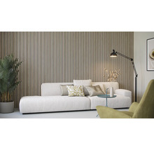 Wohnzimmer mit Holzpaneelwand, Sofa, Stehlampe und Zimmerpflanze.