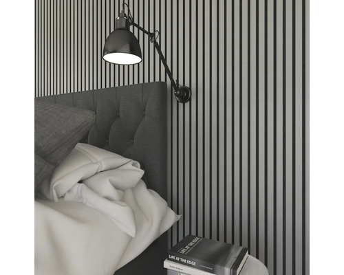 Schlafzimmer mit Bett, Wandleuchte und Nachttisch mit Buch