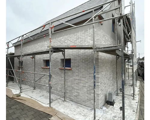 Hausfassade mit Gerüst und Mauerwerk