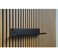 Schwarzes Wandregal an einer Holzpaneelwand
