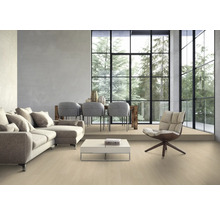 Wohnzimmer mit Sofa, Stühlen, Tisch und großem Fenster mit Blick auf Bäume