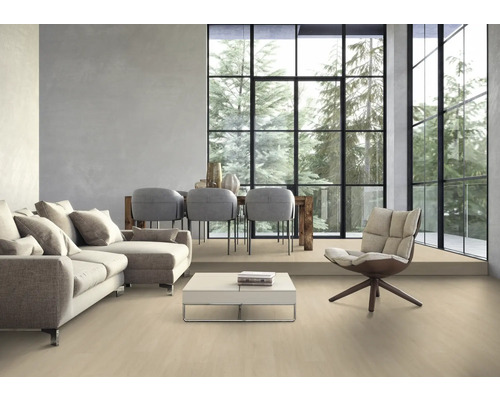 Wohnzimmer mit Sofa, Stühlen, Tisch und großem Fenster mit Blick auf Bäume