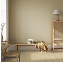 Heller Raum mit Holzmöbeln, Bank, Bücherstapel und Textilien für eine gemütliche Atmosphäre.