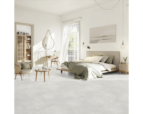 Helles Schlafzimmer mit Bett, Sitzgelegenheit, Schrank und Dekor auf hellem Boden