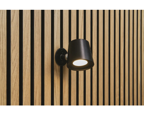 Sonava Light Akku Wandleuchte rund dimmbar 85 x 75 x 110 mm Kunststoffgehäuse schwarz inkl. Bewegungssensor, Montagematerial + 1 Fernbedienung Schwarze Wandleuchte an einer Wand mit Holzpaneelen