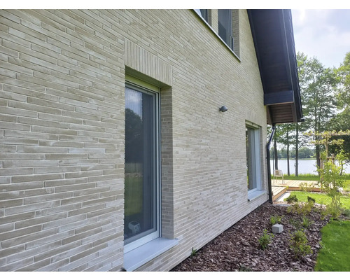 Außenansicht eines Hauses mit Ziegelmauerwerk und Fenstern