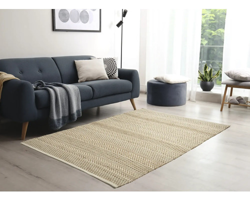 Wohnzimmer mit Sofa, Hocker und gemustertem Teppich