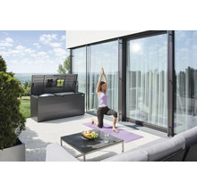 Terrasse mit einer geöffneten Aufbewahrungsbox und einer Frau, die Yoga macht