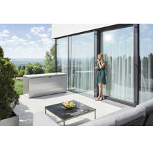 Szene mit einer Aufbewahrungsbox aus Metall auf einer Terrasse mit einer Frau, einem Tisch und Gartenmöbeln