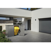 Mülltonnenbox aus Metall mit gelber Mülltonne vor einem modernen Haus