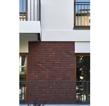 Fassade eines Gebäudes mit rotem Ziegelmauerwerk und Balkonen