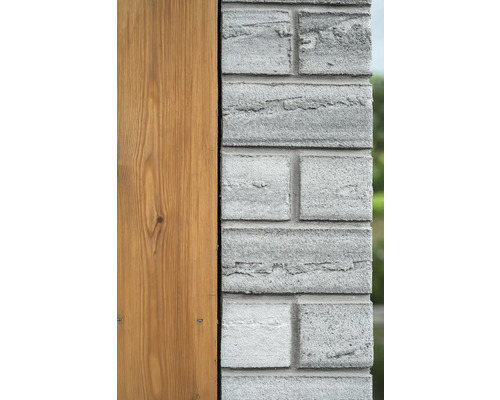Detailansicht einer Fassade mit Holzverkleidung und Mauerwerk