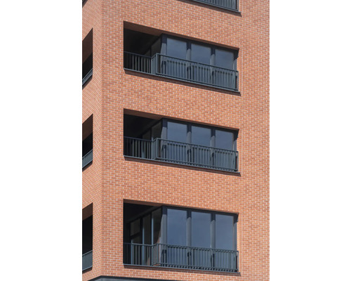 Fassade eines Wohngebäudes mit Balkonen und Ziegelmauerwerk