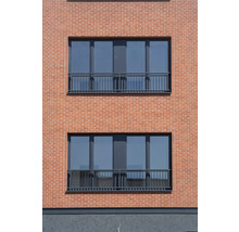 Fassade eines Hauses mit Ziegelmauerwerk und Fenstern mit Geländer