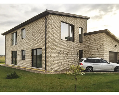 Außenansicht eines zweistöckigen Hauses mit Garage, Backsteinfassade und Rasenfläche