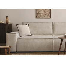 Cordsofa mit Kissen und Beistelltischen in einem Wohnzimmer