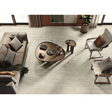 Helles Wohnzimmer mit Sofa, Sesseln, Couchtisch und Holzbodenfliesen in Holzoptik.