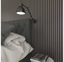 Schlafzimmer mit Bett, Wandleuchte und Wandpaneelen