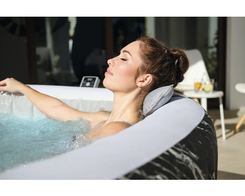 Frau entspannt in einem aufblasbaren Whirlpool mit Kopfstütze