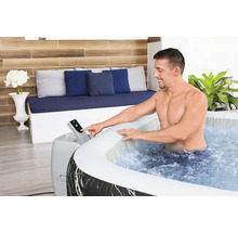Mann bedient das Bedienfeld eines aufblasbaren Whirlpools im Innenbereich