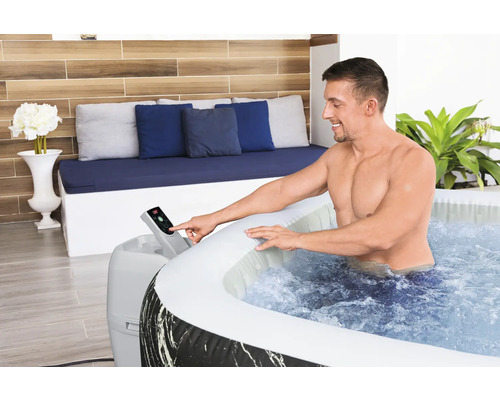 Mann bedient das Bedienfeld eines aufblasbaren Whirlpools im Innenbereich