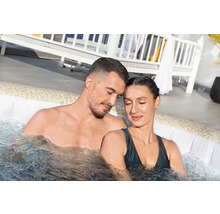Ein Paar entspannt in einem aufblasbaren Whirlpool mit Wassermassagefunktion.
