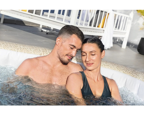 Ein Paar entspannt in einem aufblasbaren Whirlpool mit Wassermassagefunktion.
