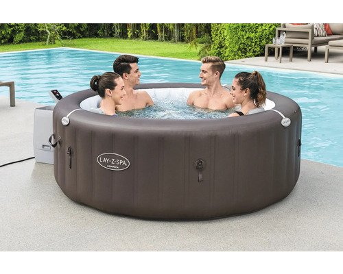 Aufblasbarer Lay-Z-Spa Whirlpool mit vier Personen im Wasser neben einem Pool