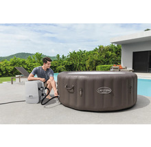 Aufblasbarer Lay-Z-Spa Whirlpool mit Mann bei der Installation im Garten.