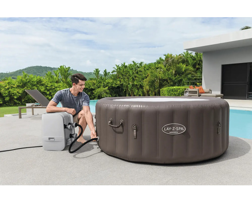 Aufblasbarer Lay-Z-Spa Whirlpool mit Mann bei der Installation im Garten.