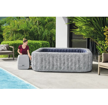 Aufblasbarer Lay-Z-Spa Whirlpool mit Frau und Pumpe im Garten.