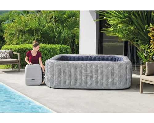 Aufblasbarer Lay-Z-Spa Whirlpool mit Frau und Pumpe im Garten.