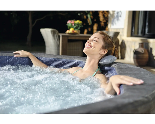 Frau entspannt im aufblasbaren Whirlpool im Freien.