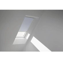 Dachfenster mit teilweise heruntergelassenem Rollo in einem Dachzimmer