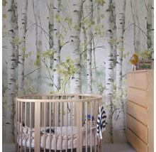 Kinderzimmer mit einer Tapete mit Birkenmotiv, einem runden Babybett und einer Kommode