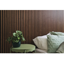 Raum mit Bett, Wandpaneelen und Beistelltisch mit Pflanze