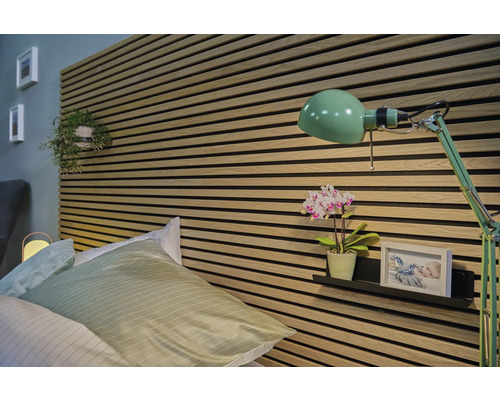 Schlafzimmer mit Bett, Wandpaneelen und grüner Lampe