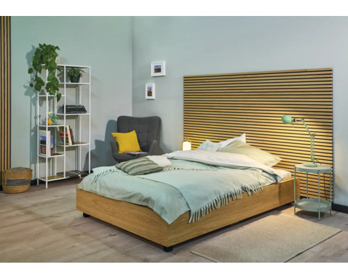 Helles Schlafzimmer mit Bett, Nachttisch, Regal und Sessel