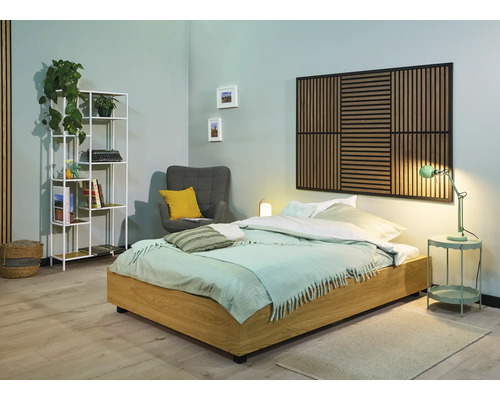 Helles Schlafzimmer mit Bett, Nachttisch, Lampe, Sessel, Regal und Wandpaneel für eine freundliche Atmosphäre