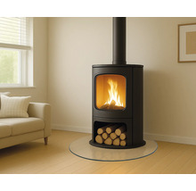 Kaminofen mit Holzscheitlager und Glasbodenplatte in einem Wohnzimmer.
