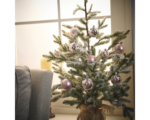 Dekorierter Miniaturweihnachtsbaum mit Kugeln in einem Jutesack