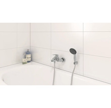 Badezimmer mit Badewanne, Armatur und Handbrause sowie Seife und Shampoo
