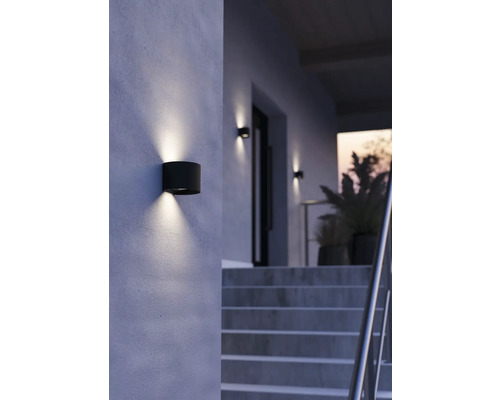 Außenwandleuchte in zylindrischer Form spendet Licht an einer Hauswand