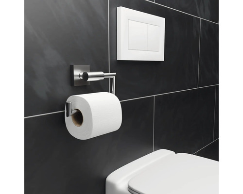 Toilette mit Toilettenpapierhalter, Spültaste und dunklem Fliesenhintergrund
