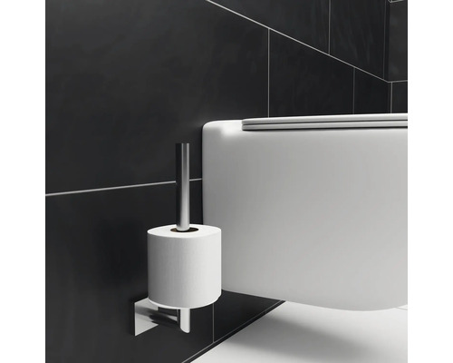 Detailaufnahme einer Toilette mit Toilettenpapierhalter an der Wand.