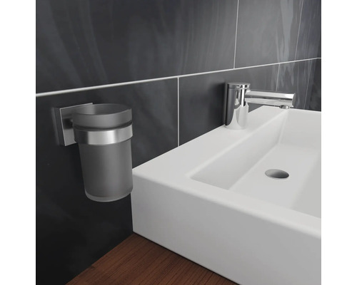 Detailaufnahme eines Waschbeckens mit Armatur und Zahnputzbecherhalter im Badezimmer