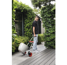 Mann transportiert Blumentopf mit einer Sackkarre im Garten.