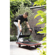 Mann bedient einen Transportroller im Garten.