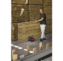 Mann transportiert Holzzaunelement mit Transportwagen