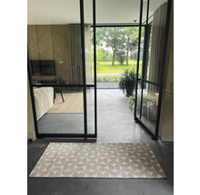 Innenraum mit Teppich, Glastüren und Blick auf den Garten.